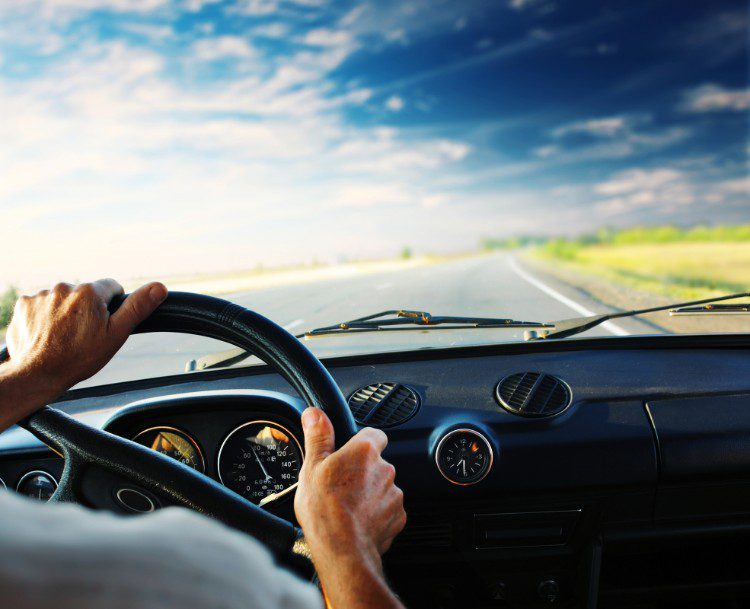 man driving car with blue sky 